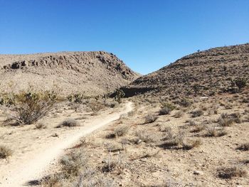 Scenic view of desert against clear blue sky