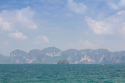 Scenic view of sea by mountains against sky