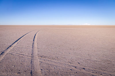 Scenic view of desert against clear blue sky