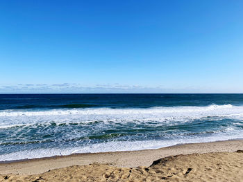 Scenic view of sea against clear blue sky