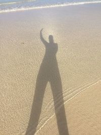 Shadow of person on sand at beach