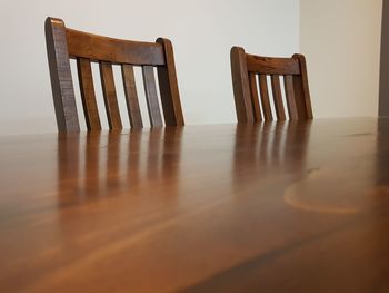 Close-up of wooden chairs at table