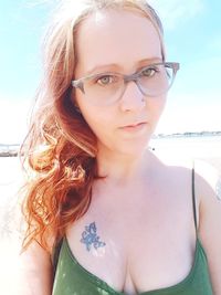 Portrait of young woman with eyeglasses on beach