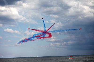 Airplane flying over sea against sky