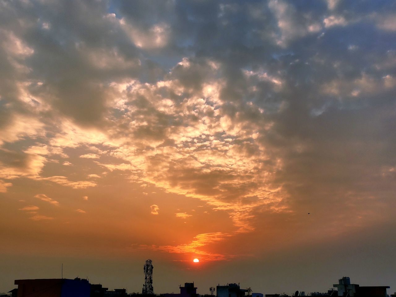 LOW ANGLE VIEW OF SILHOUETTE BUILDINGS AGAINST CLOUDY SKY