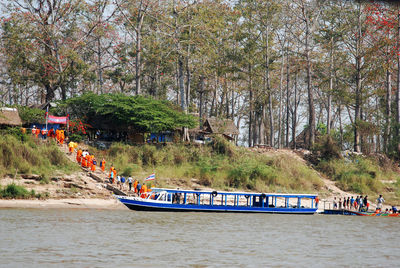 Boats in river against trees