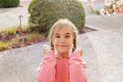 A girl enjoys sakura blossoms while walking through the cherry orchard in spring