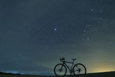 Low angle view of bicycles against sky at night