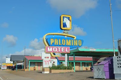 Information sign on road against sky