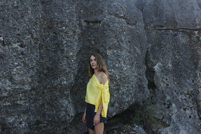 Full length of woman standing against rock