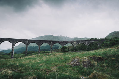 Arch bridge over land against sky