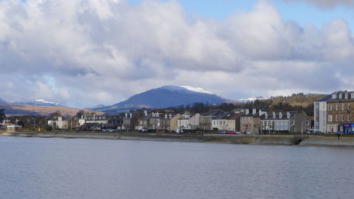 Scenic view of river and mountains against cloudy sky