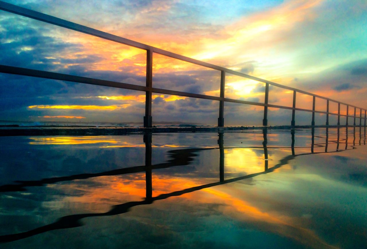 sunset, sky, cloud - sky, water, reflection, orange color, scenics, beauty in nature, sea, tranquility, tranquil scene, railing, nature, dramatic sky, cloud, cloudy, idyllic, dusk, built structure, weather