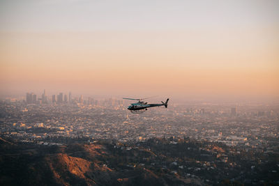 Aerial view of city against sky during sunset