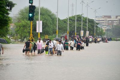 Group of people walking on road in rainy season