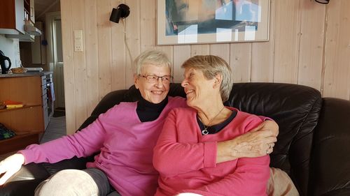 Happy senior women sitting on sofa at home