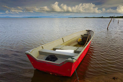 Boat moored on sea against sky