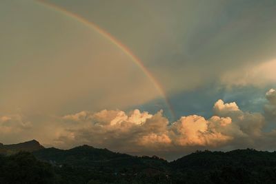 Low angle view of rainbow over mountain against sky