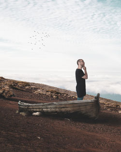 Full length of woman sitting on land against sky