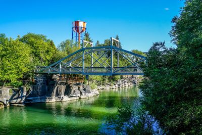 Low angle view of water tower against clear blue sky