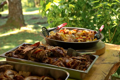 Closeup of baked meat and potatoes with vegetables on rustic table