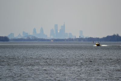 Scenic view of sea by buildings against sky in city