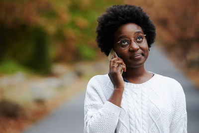 Woman talking on phone while standing outdoors