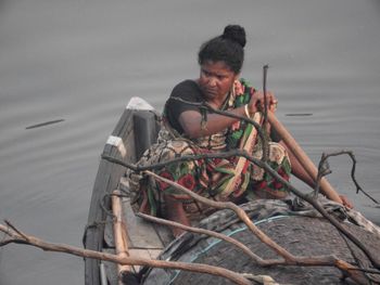 Man sitting on boat against sea