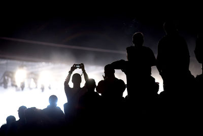 Silhouette people photographing at music concert