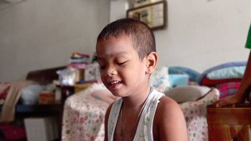 Portrait of smiling boy sitting at home