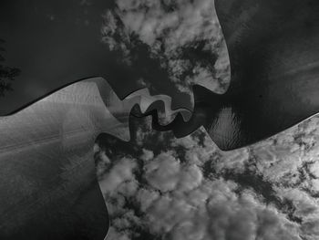 Digital composite image of hand against sky