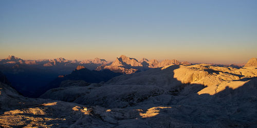 Scenic view of snowcapped mountains against clear sky during sunset