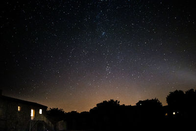 Low angle view of silhouette trees against sky at night