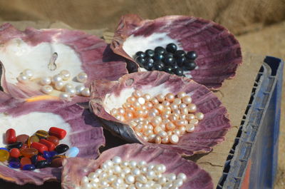 Various beads in oyster shells on table
