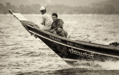 People sitting on boat sailing in sea