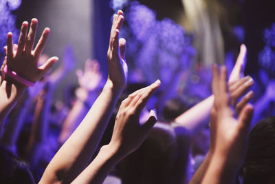 Midsection of people enjoying at music concert