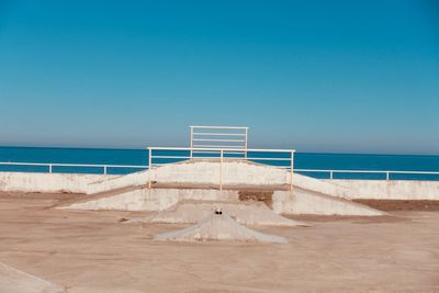 Scenic view of beach against clear blue sky