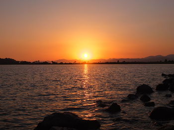 Scenic view of sea against orange sky