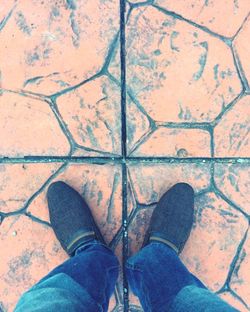 Low section of man standing on cobblestone