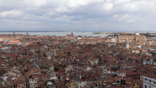 Aerial view of town by sea against sky