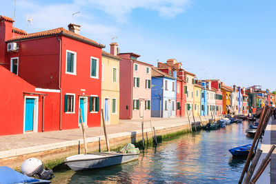 View of canal amidst buildings against sky