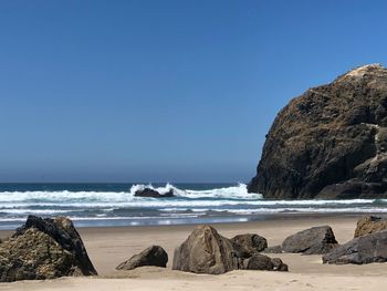 Scenic view of beach against clear blue sky