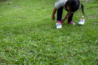 Rear view of woman playing golf on field