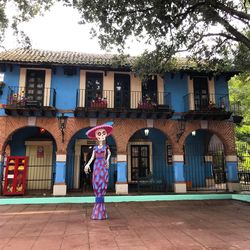 Full length of woman standing by building in city