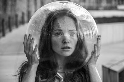 Scared young woman wearing glass helmet in head on sidewalk