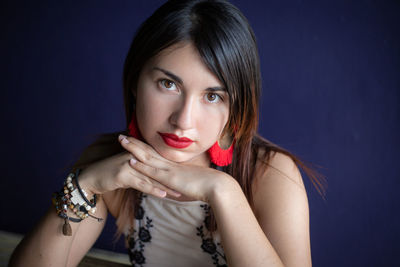 Portrait of beautiful young woman against gray background