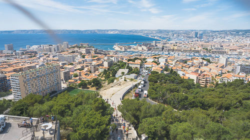 High angle view of townscape by sea against sky