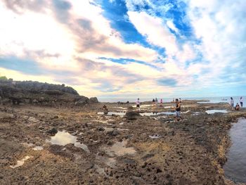 People on beach against sky