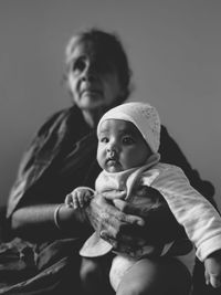 Low angle view of grandmother holding granddaughter while sitting at home