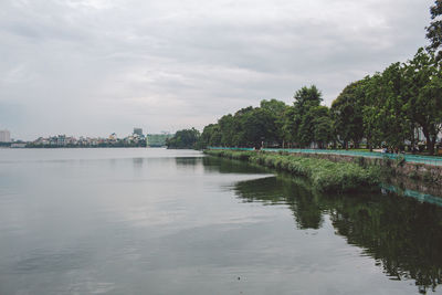 Scenic view of lake against sky in city